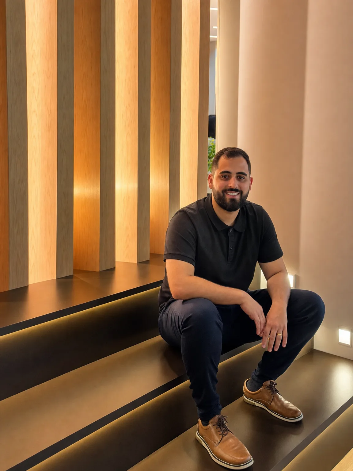 Gustavo Donizete, fundador da LED DONIZETE, sentado em degraus com luz de LED