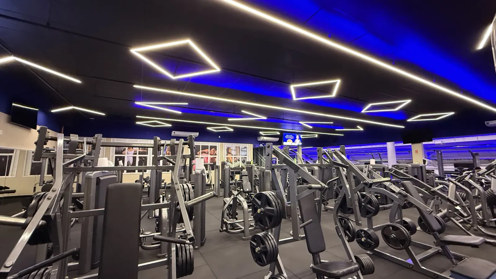 Salão de musculação com molduras de perfil de LED no teto preto