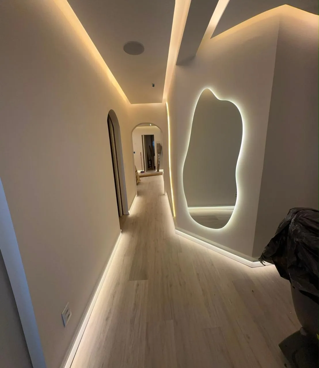 Corredor com rodapé e espelho iluminados