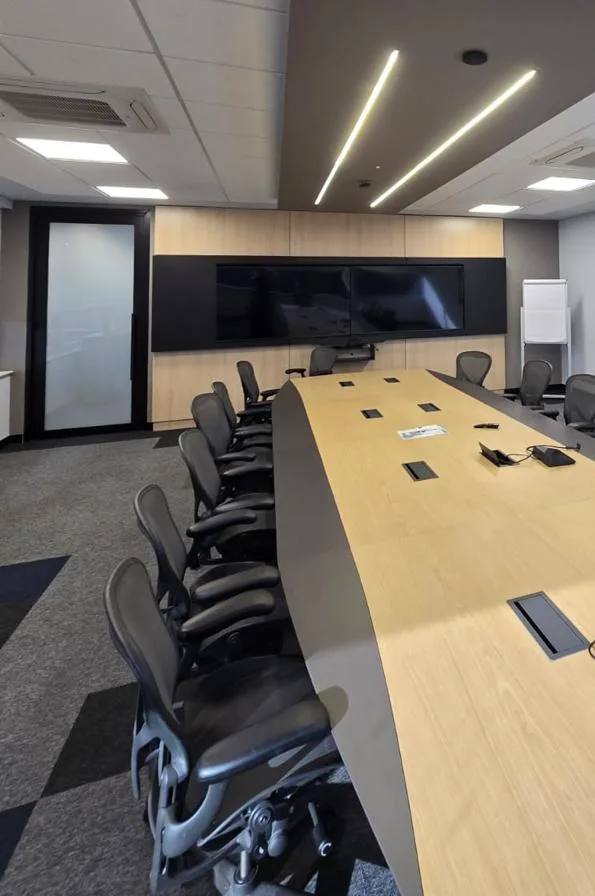 Mesa de reunião sob linhas de perfil de LED