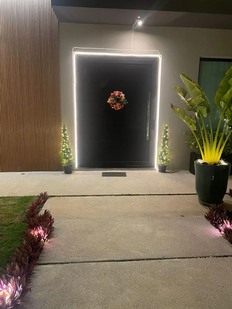 Porta de entrada contornada por luz e guirlanda