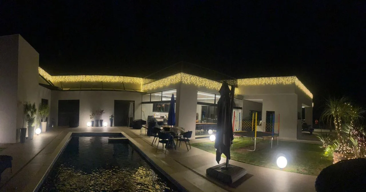 Área externa com piscina e cascata de luz